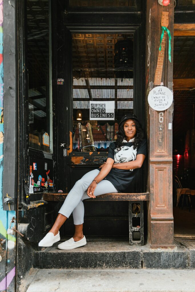 Woman sitting on a chair in the doorway of her business