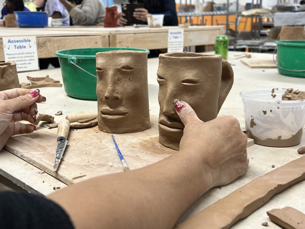 Two clay mugs with faces on them